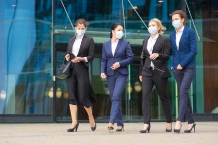 Group of female colleagues in office suits and masks